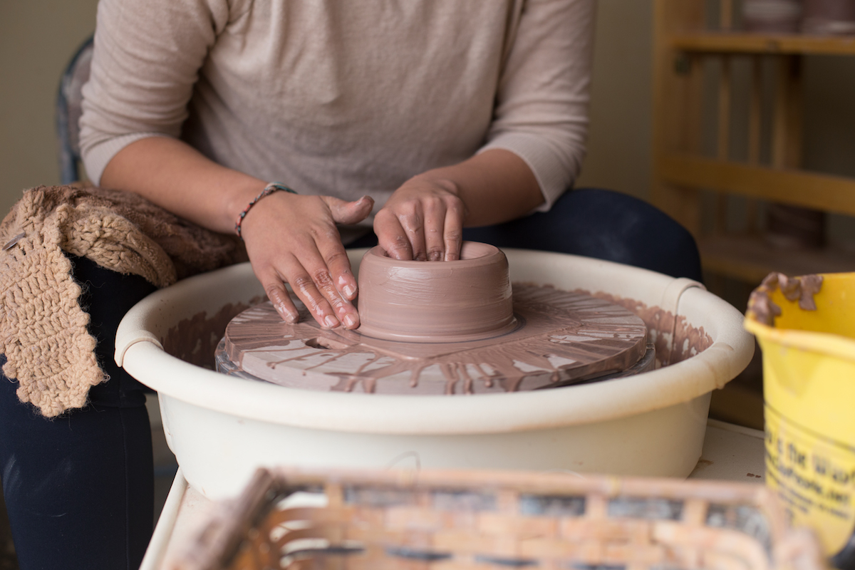 someone throwing on a ceramic wheel