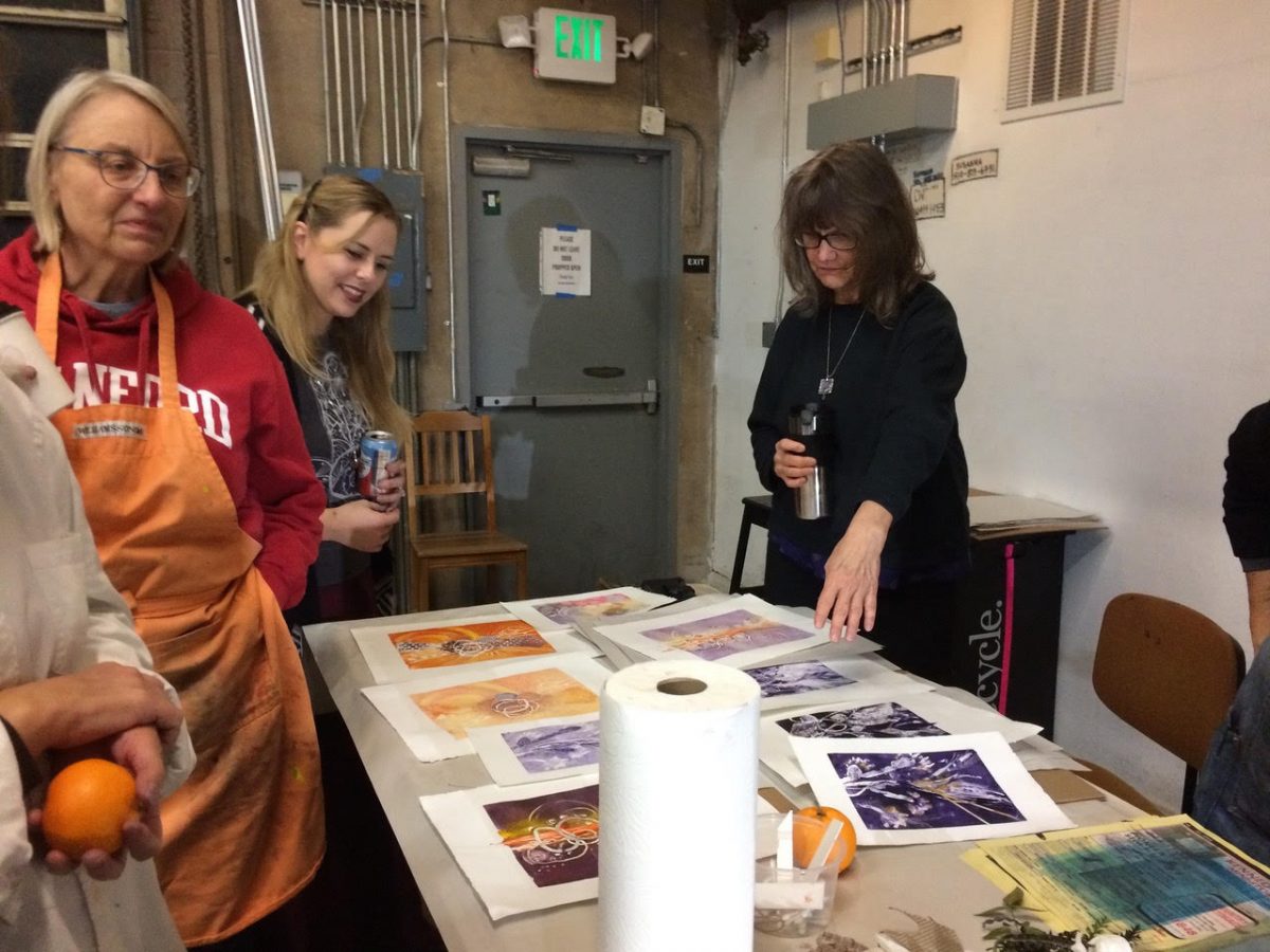 Two women admiring prints they made in Myrtle Press
