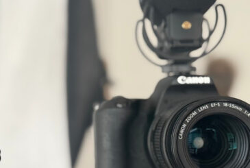 Canon DSLR with 18-55mm lens and a mounted external microphone, ready for recording