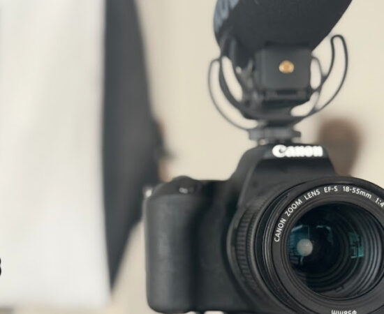 Canon DSLR with 18-55mm lens and a mounted external microphone, ready for recording