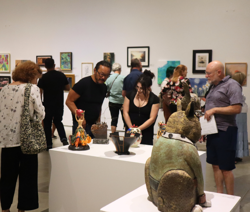 second saturday - Verge Center for the Arts Visitors in an art gallery examine ceramic sculptures on white pedestals, with a large green-brown animal statue with long ears in the foreground.